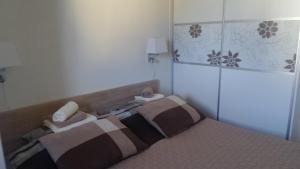 a small bedroom with a bed with a head board at Apartman Ena in Vlasic