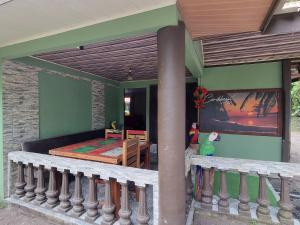 a house with a balcony with a bed and a table at Caribbean View House in Tortuguero