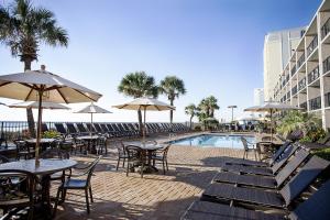 an outdoor patio with tables and chairs and a pool at Compass Cove in Myrtle Beach