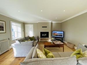a living room with two couches and a tv at The Granary, Luxuriously Restored Barn on a Farm in Thurles