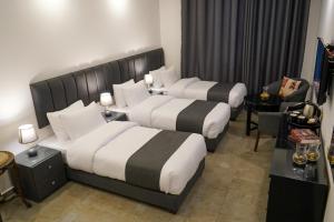 Habitación de hotel con 2 camas y sofá en Torino Hotel Amman, en Amán