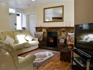a living room with a couch and a fireplace at The East Wing At Grove Hall in Bodfari