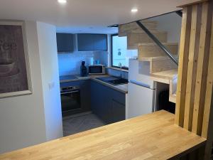 a kitchen with blue cabinets and a white refrigerator at Appartement T3 proche mairie, château, et gare in Rambouillet