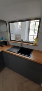 a kitchen counter with a sink and a window at Appartement T3 proche mairie, château, et gare in Rambouillet
