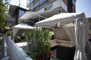 un patio esterno con ombrellone e sedie e un edificio di Hotel Genty a Rimini