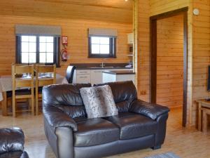 a leather couch in a living room with a kitchen at Exmoor - Uk12539 in Witheridge