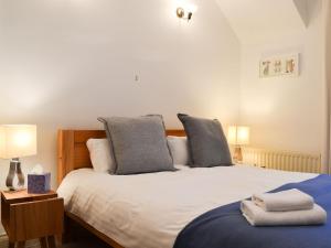 a bedroom with a large white bed with two pillows at Lythdene in Grange Over Sands