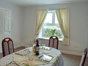 a dining room table with wine glasses and a window at Brick Cottage 2-uk13675 in Palnure