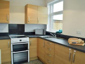 a kitchen with a sink and a stove top oven at Brick Cottage 2-uk13675 in Palnure