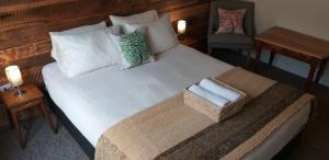 ein Bett mit zwei Kissen und einem Stuhl in einem Zimmer in der Unterkunft Treehouse Patagonia in Puerto Natales