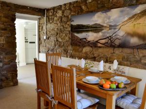 a dining room with a wooden table with fruit on it at The Nook in Mealsgate