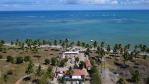 uma vista aérea de um resort com palmeiras e o oceano em Pousada Costa dos Corais em São José da Coroa Grande