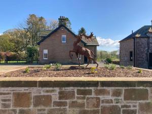 une statue d'un cheval devant une maison dans l'établissement Halleaths Home Farm, à Lochmaben