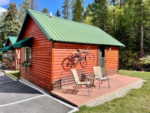 a cabin with two chairs and a bike on it at Whitetail Creek Resort in Lead