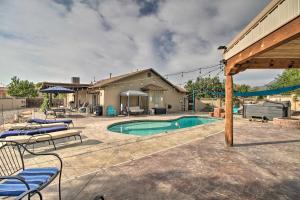 a swimming pool with lounge chairs and a house at Albuquerque Studio with Shared Pool and Fire Pit! in Albuquerque
