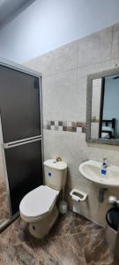 a bathroom with a toilet and a sink at HOTEL CONTINENTAL.M in Puerto Boyacá