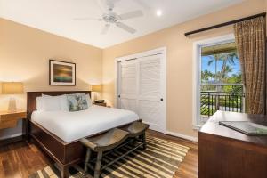 a bedroom with a bed and a desk and a window at Turtle Bay Villas in Kahuku