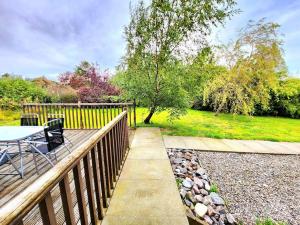 una terraza de madera con mesa y sillas. en Boutique Four Bed Holiday Home in Inverness, en Inverness