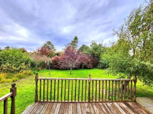 um banco de madeira sentado em cima de um campo em Boutique Four Bed Holiday Home in Inverness em Inverness