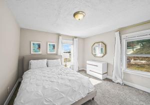 a white bedroom with a bed and a window at Tremont! 7 min to downtown Cleveland in Cleveland