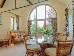a living room with a table and chairs and a large window at Courtyard Lodge in Edwinstowe