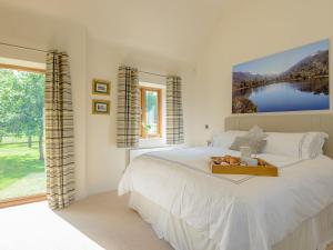 a bedroom with a bed with a tray of fruit on it at Courtyard Lodge in Edwinstowe