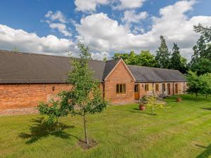 a brick building with a tree in front of it at Courtyard Lodge in Edwinstowe