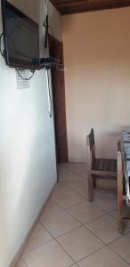 a room with a refrigerator and a table and a chair at Centro Ilha comprida in Ilha Comprida