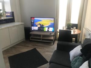 a living room with a couch and a flat screen tv at Executive Apartment Central Doncaster in Doncaster