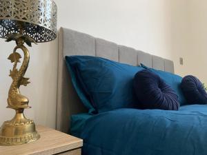 una lámpara de oro en una mesa junto a una cama azul en Executive Apartment Central Doncaster en Doncaster