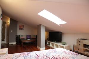 Schlafzimmer mit einem Bett und einem Flachbild-TV in der Unterkunft Habitación con baño, cerca de la playa in Sopelana