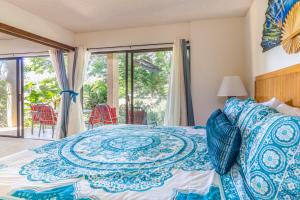 a bedroom with a bed with a blue and white bedspread at Hale Honu in Waikoloa Village