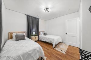 a white bedroom with two beds and a window at Saffron Door Sanctuary, near downtown Atlanta! in Atlanta