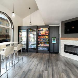 un restaurante con chimenea y un bar con sillas en Homestay Suites - Studios & Spas, en Moreno Valley