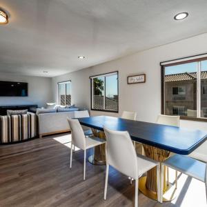 comedor con mesa azul y sillas blancas en Homestay Suites - Studios & Spas, en Moreno Valley