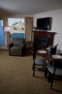 a living room with a fireplace and a table and chairs at Oceancliff I & II, a VRI resort in Newport