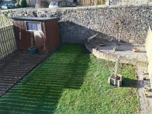 a garden with a wooden shed and some grass at Vale View in Richmond