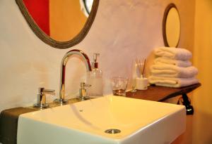 a bathroom with a sink and a mirror and towels at Cabañas Azul Andino in Purmamarca