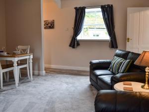 a living room with a couch and a table at Mill Force Cottage in Bowes