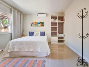 een slaapkamer met een wit bed en een kast bij Brasil Buzios in Búzios