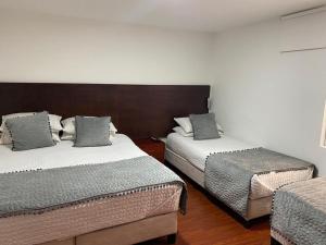 sypialnia z 2 łóżkami i krzesłem w obiekcie Hotel Harrington 63 w mieście Bogota