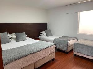sypialnia z 2 łóżkami pojedynczymi i oknem w obiekcie Hotel Harrington 63 w mieście Bogota
