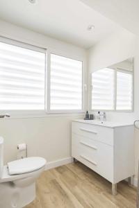 a white bathroom with a toilet and a sink at Eurosol sunny beach apartment in Torremolinos