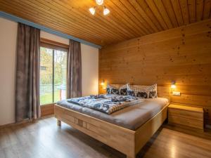 a bedroom with a bed with a wooden wall at Chalet Rosa in Reith im Alpbachtal