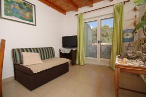a living room with a chair and a sliding glass door at Seaside secluded apartments Cove Karkavac - Scedro, Hvar - 8801 in Jelsa