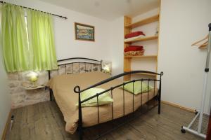 a bedroom with a bed with a green curtain at Seaside secluded apartments Cove Karkavac - Scedro, Hvar - 8801 in Jelsa