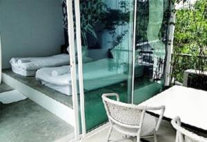 a room with a balcony with a table and a chair at White@Sea Resort in Ban Phe