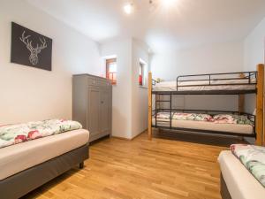2 Etagenbetten in einem Zimmer mit Holzböden in der Unterkunft Haus Bergblick in Westendorf