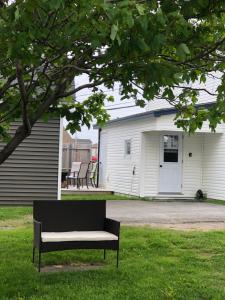 a bench sitting in the grass in front of a house at Alma’s Cape Shore Cottage! Your home away from home! in Bonavista