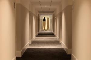 a hallway in a building with two windows at Kimpton Surfcomber Hotel, an IHG Hotel in Miami Beach